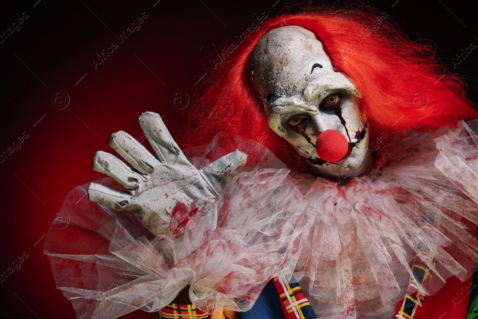 Photo of Terrifying clown on black background. Halloween party costume