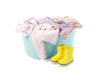 Photo of Laundry basket with baby clothes and rubber boots isolated on white