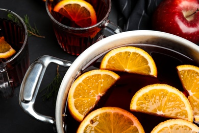 Cooking pot of tasty mulled wine with spices on table, closeup