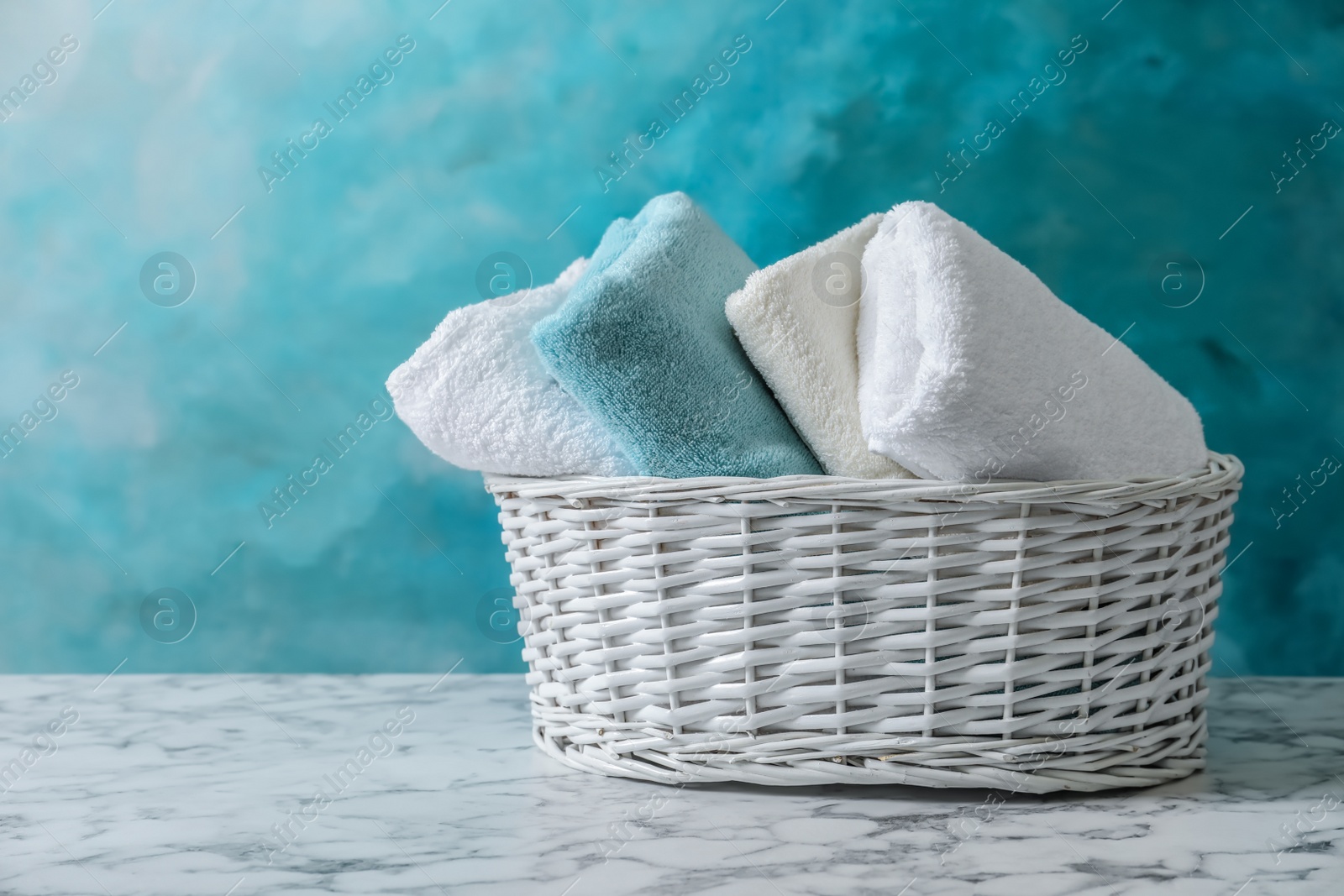 Photo of Basket with clean towels on table