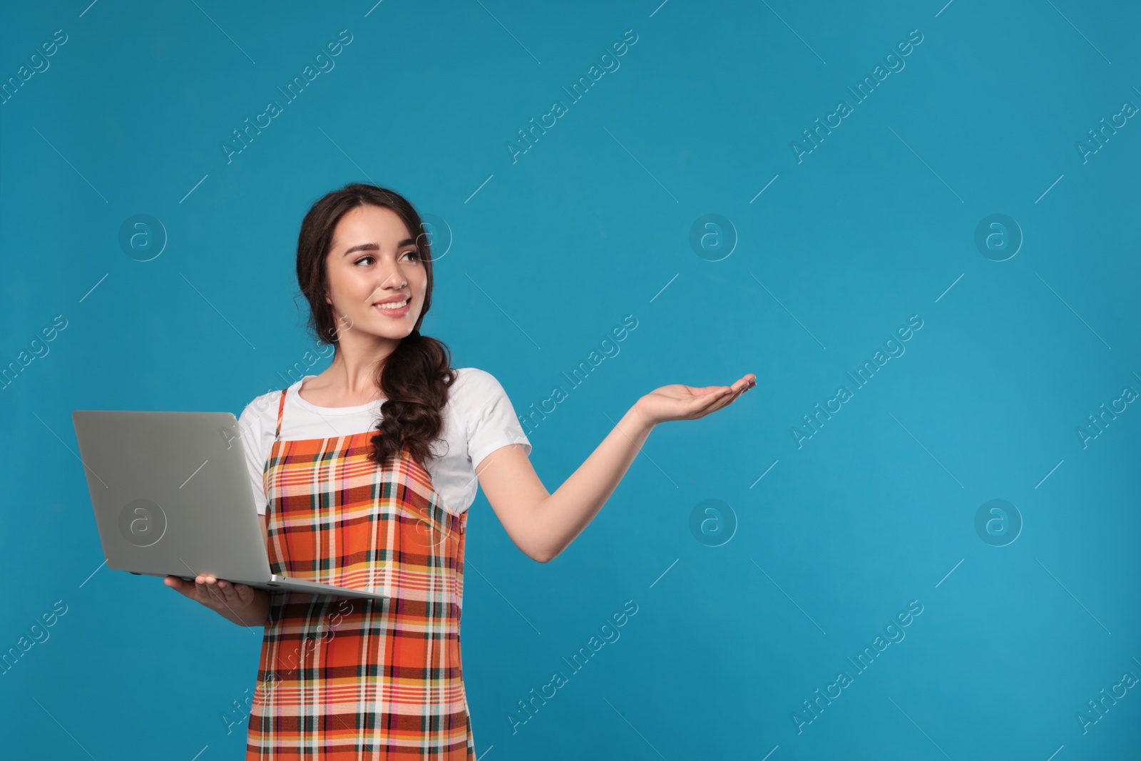 Photo of Young woman with laptop on blue background. Space for text