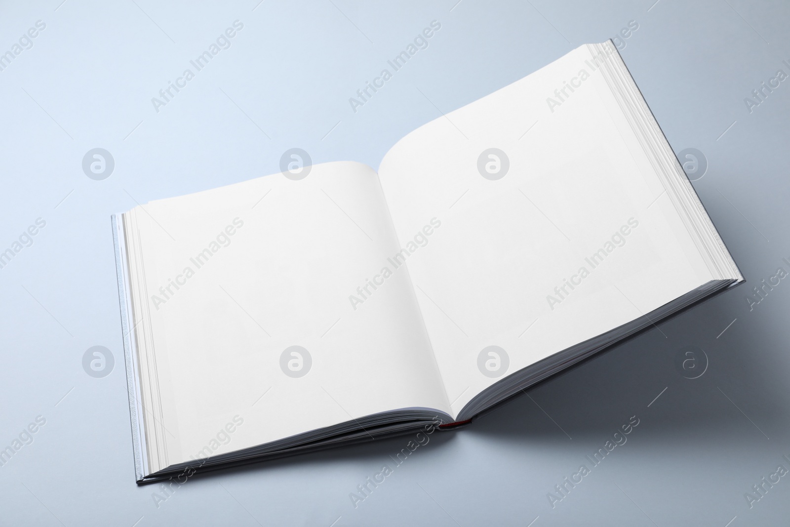 Photo of Open book with hard cover on white background