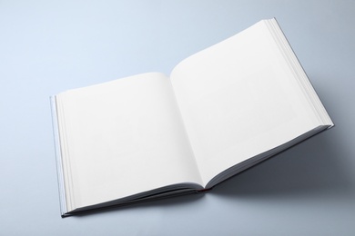 Photo of Open book with hard cover on white background