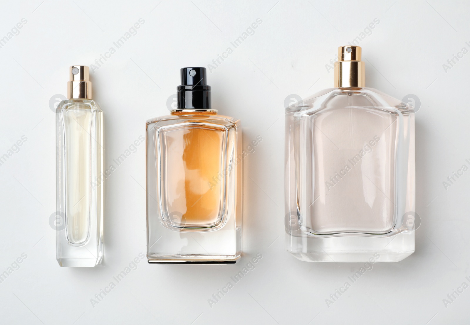 Photo of Transparent bottles of perfume on white background