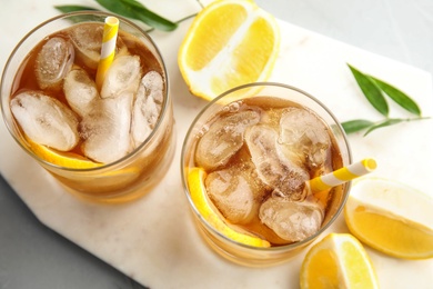 Glasses of lemonade with ice cubes and fruit on table, top view