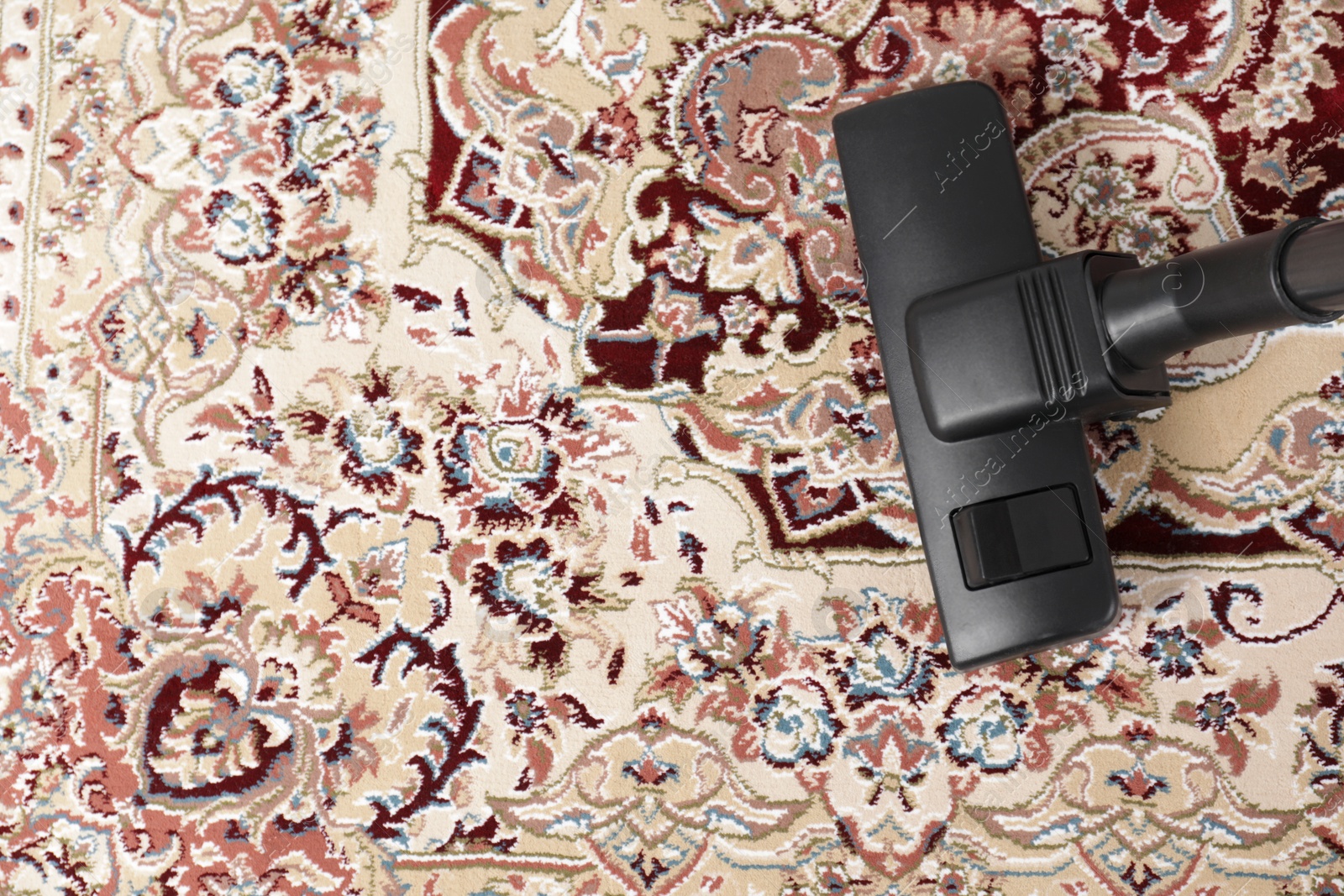 Photo of Hoovering carpet with modern vacuum cleaner indoors, top view. Space for text