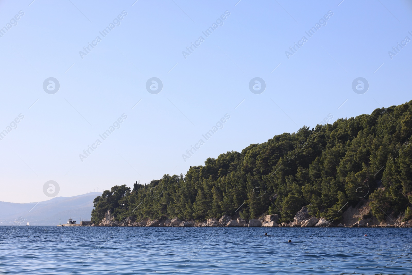 Photo of Picturesque view of beautiful sea and mountain with trees outdoors