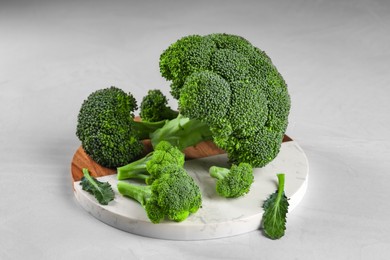 Tray with fresh raw broccoli on white table