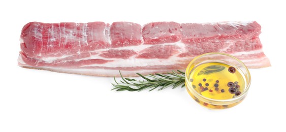 Piece of raw pork belly, rosemary and oil with spices isolated on white