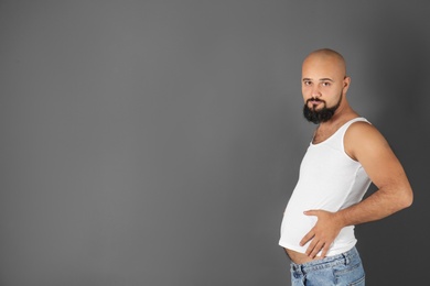Portrait of overweight man and space for text on gray background