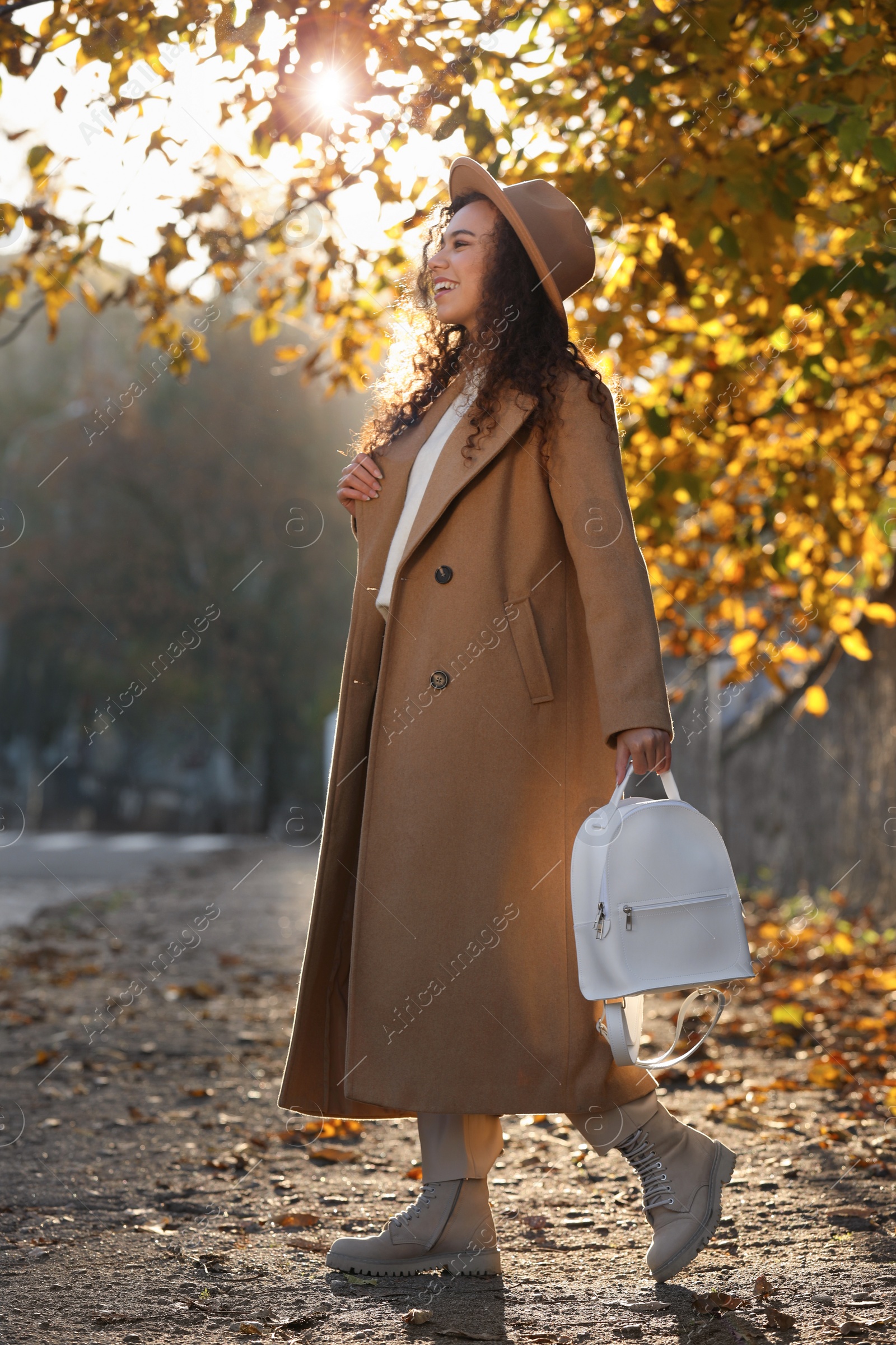 Photo of Beautiful African-American woman with stylish white backpack on city street