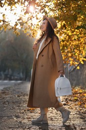 Beautiful African-American woman with stylish white backpack on city street