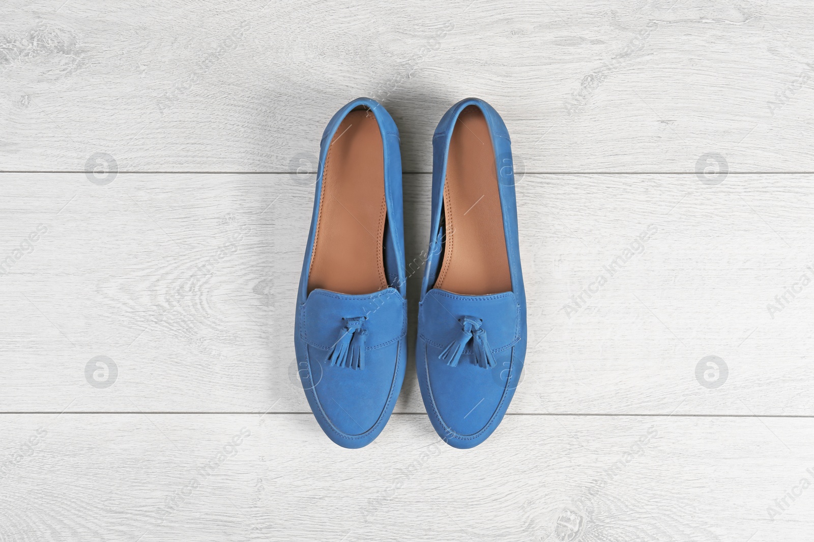 Photo of Pair of female shoes on wooden background, top view