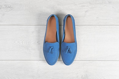 Photo of Pair of female shoes on wooden background, top view