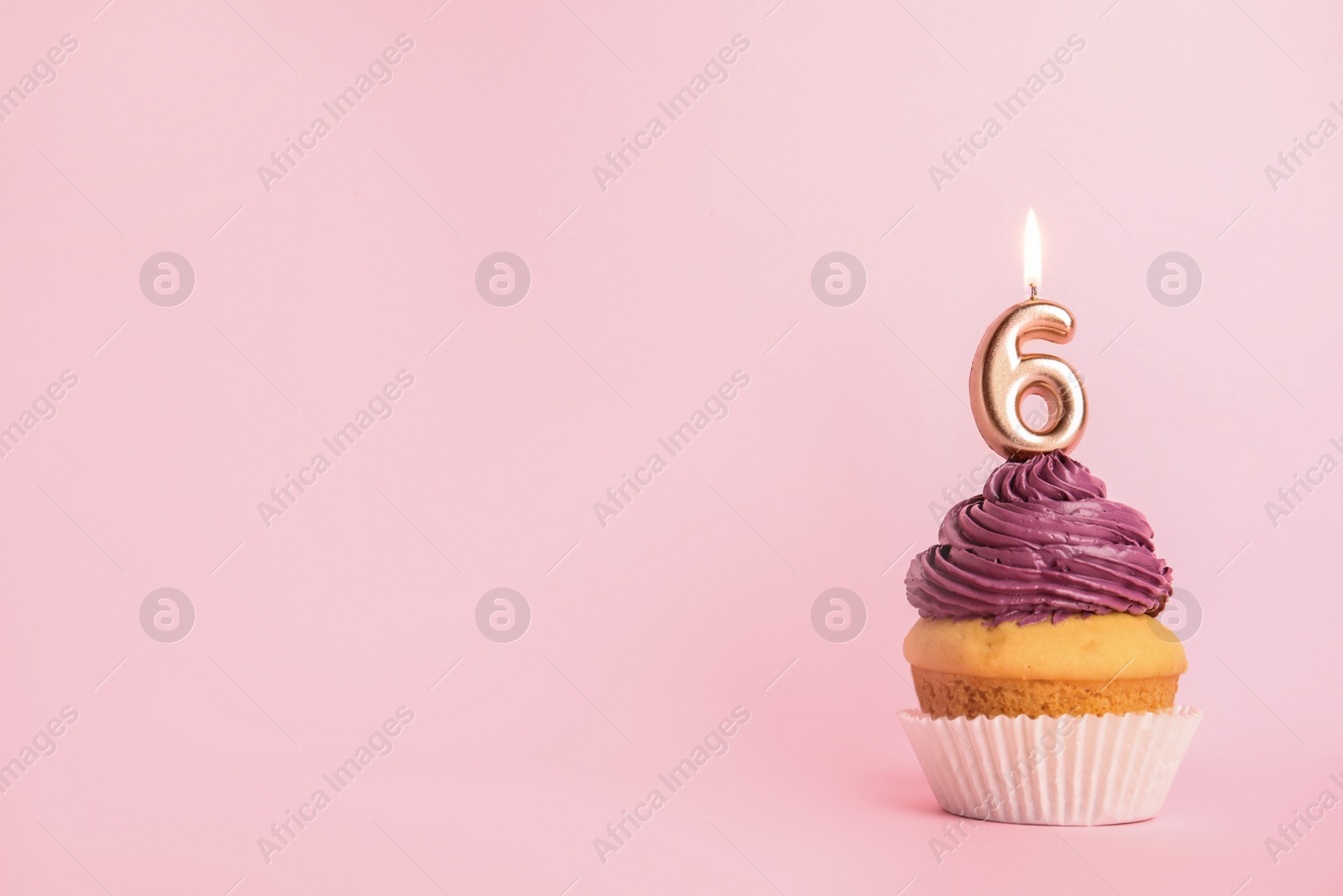Photo of Birthday cupcake with number six candle on pink background, space for text