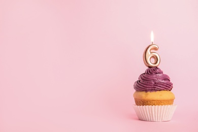 Birthday cupcake with number six candle on pink background, space for text