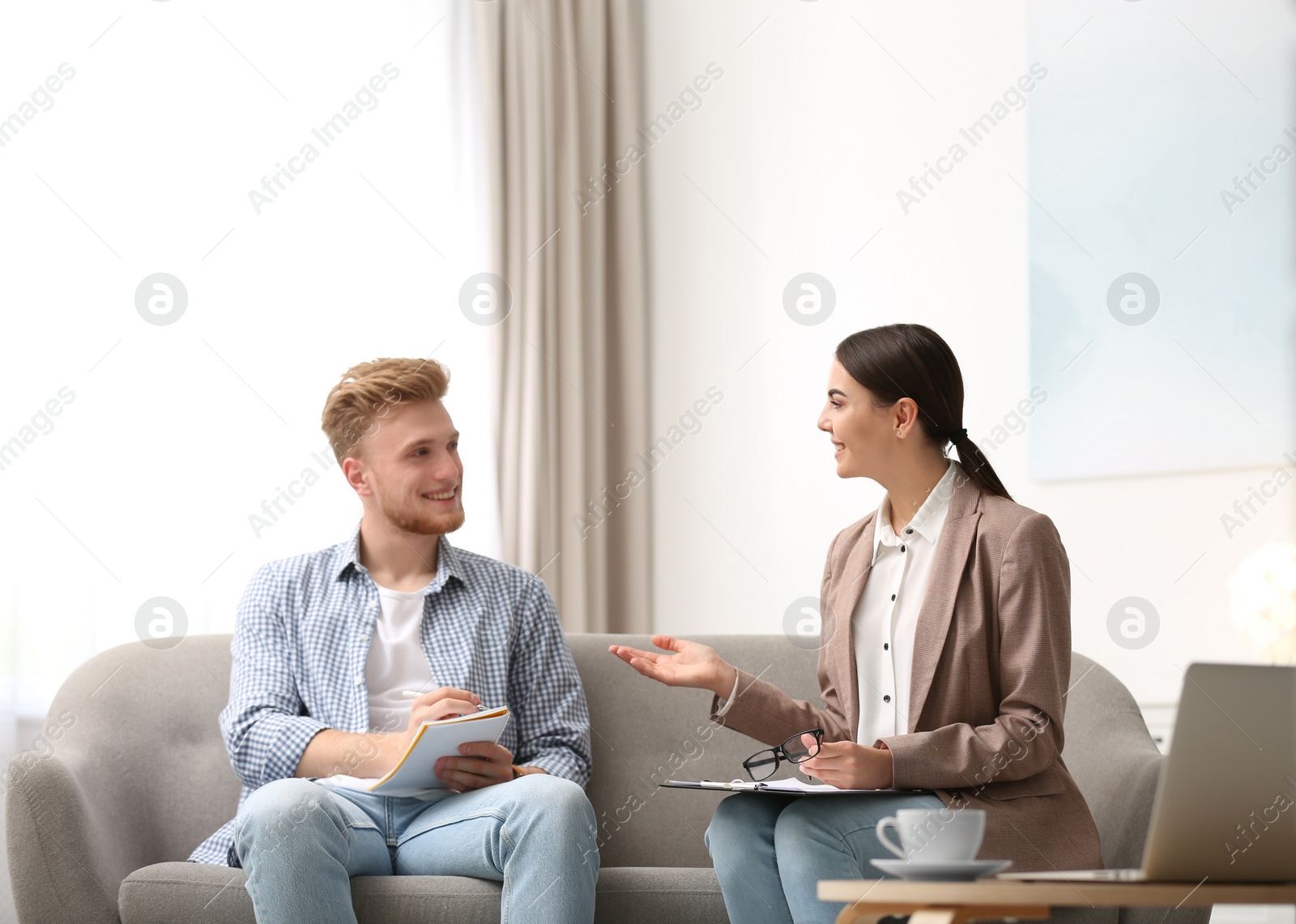 Photo of Female insurance agent consulting young man in office