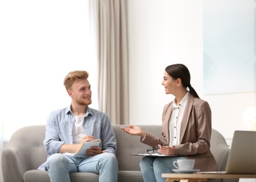 Female insurance agent consulting young man in office