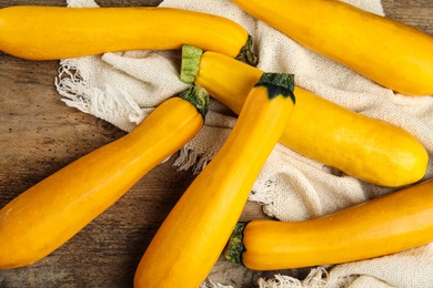 Fresh ripe yellow zucchini on wooden background, flat lay