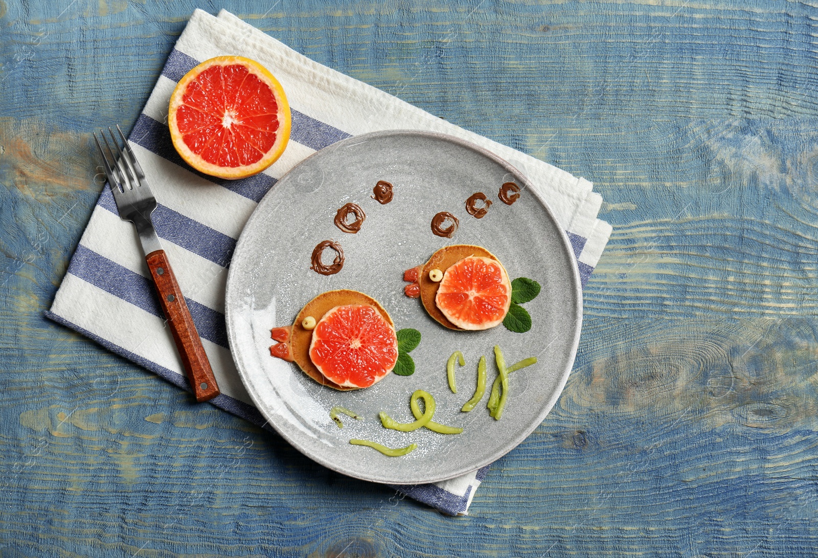 Photo of Funny pancakes for kids breakfast on wooden table, top view