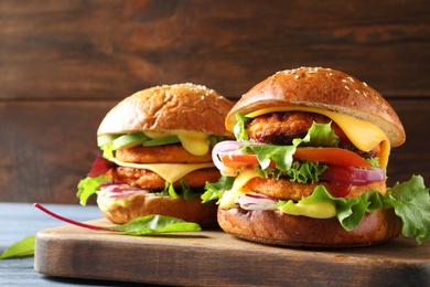 Wooden board with double vegetarian burgers on table