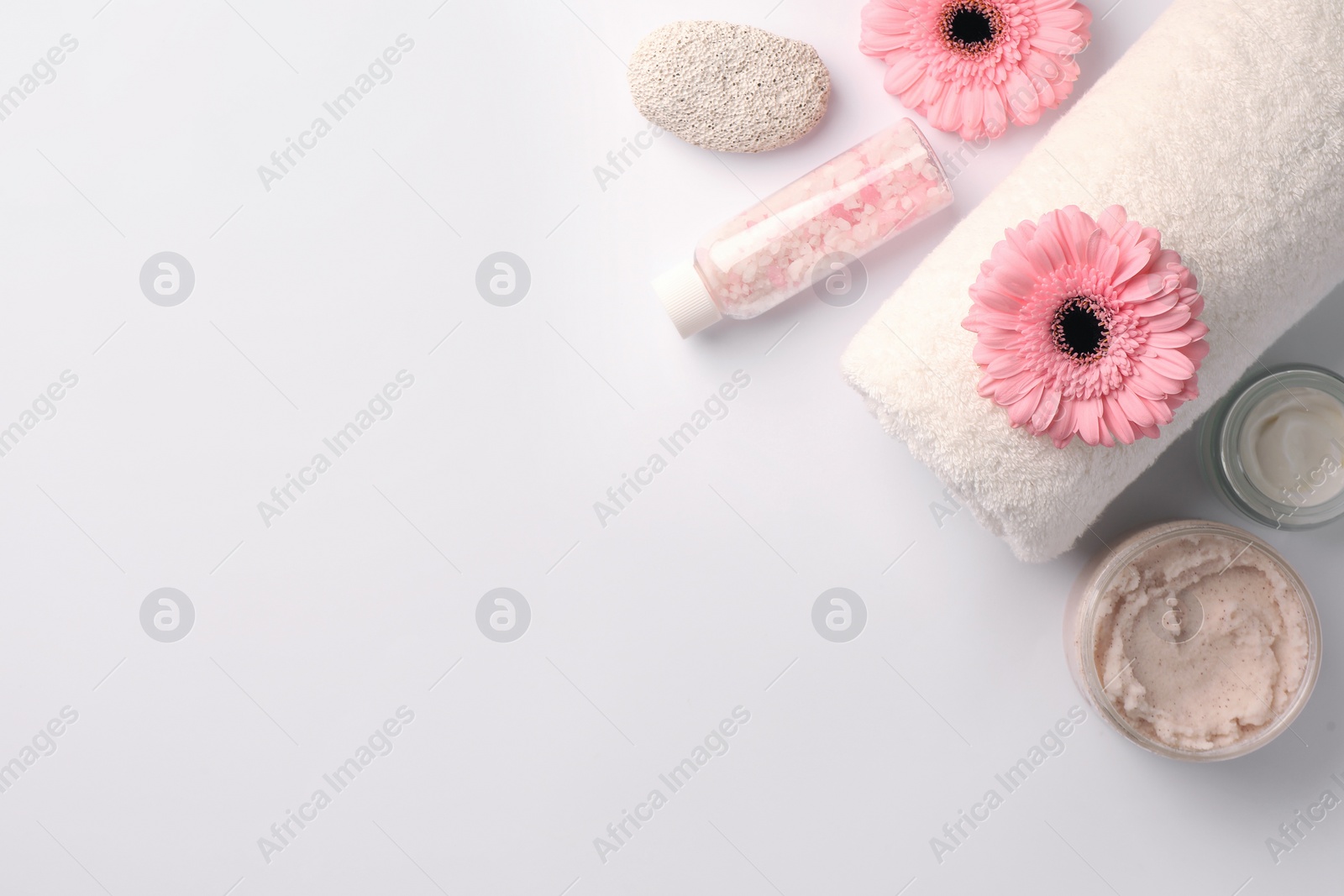 Photo of Flat lay composition with different spa products and beautiful flowers on white table. Space for text