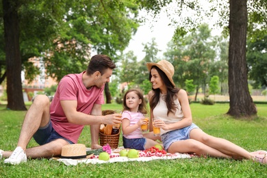 Photo of Happy family having picnic in park on summer day