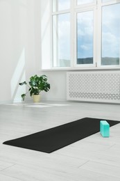Photo of Exercise mat and yoga block on floor in room