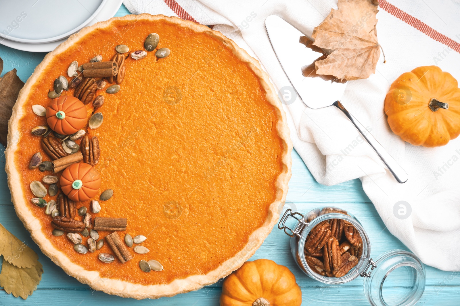 Photo of Delicious homemade pumpkin pie on light blue wooden table, flat lay