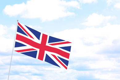 Image of Flag of Great Britain outdoors on cloudy day, space for text. Learning English