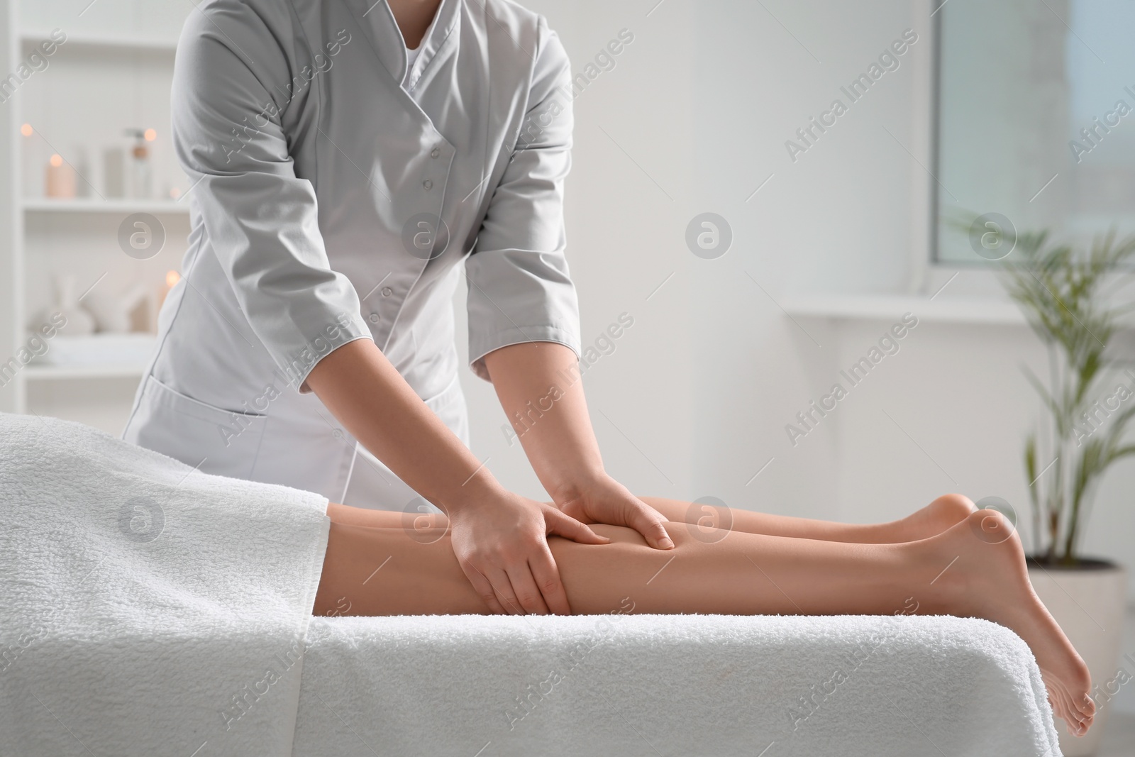 Photo of Woman receiving leg massage in spa salon, closeup