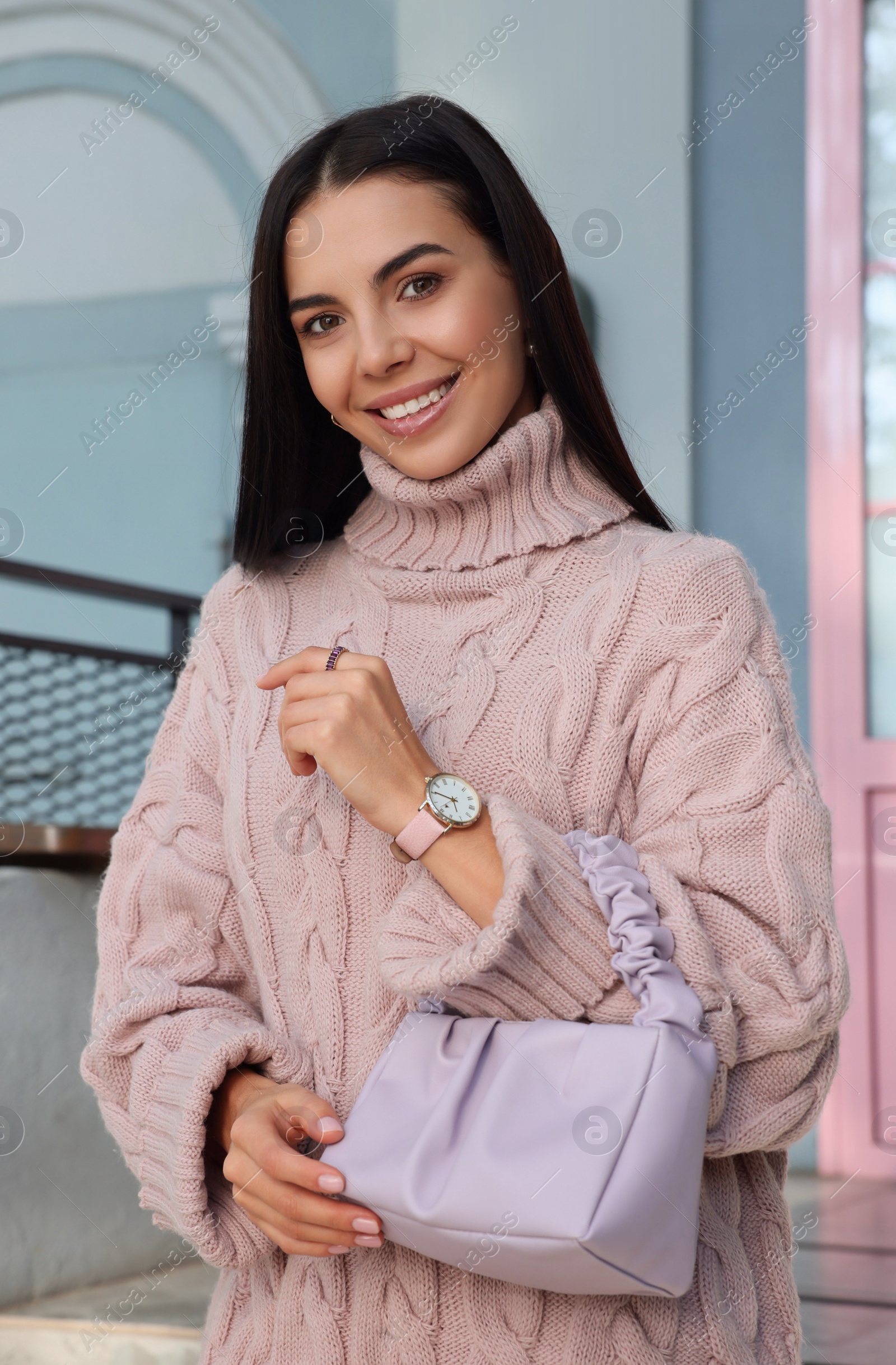 Photo of Fashionable young woman with stylish bag on city street