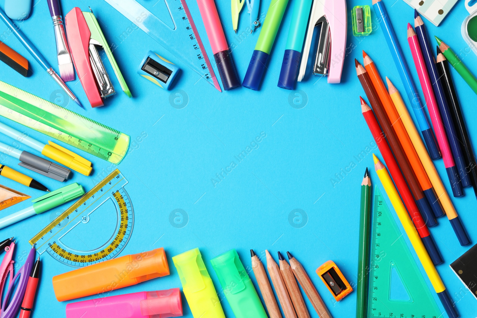 Photo of Frame of different stationery on light blue background, flat lay with space for text. Back to school