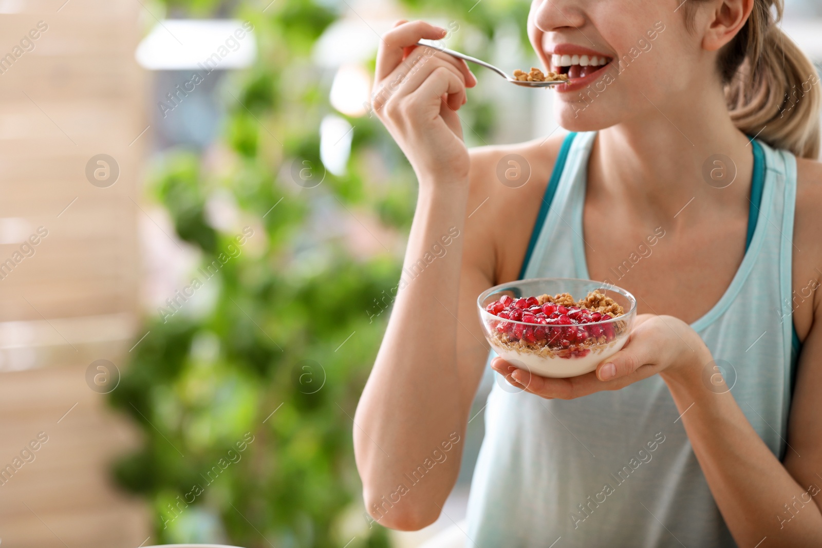 Photo of Young woman in fitness clothes having healthy breakfast at home, closeup. Space for text