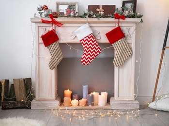 Photo of Decorative fireplace with beautiful decor and Christmas stockings indoors