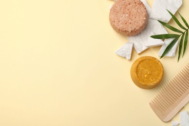 Photo of Flat lay composition of solid shampoo bars, leaf and comb on beige background. Space for text