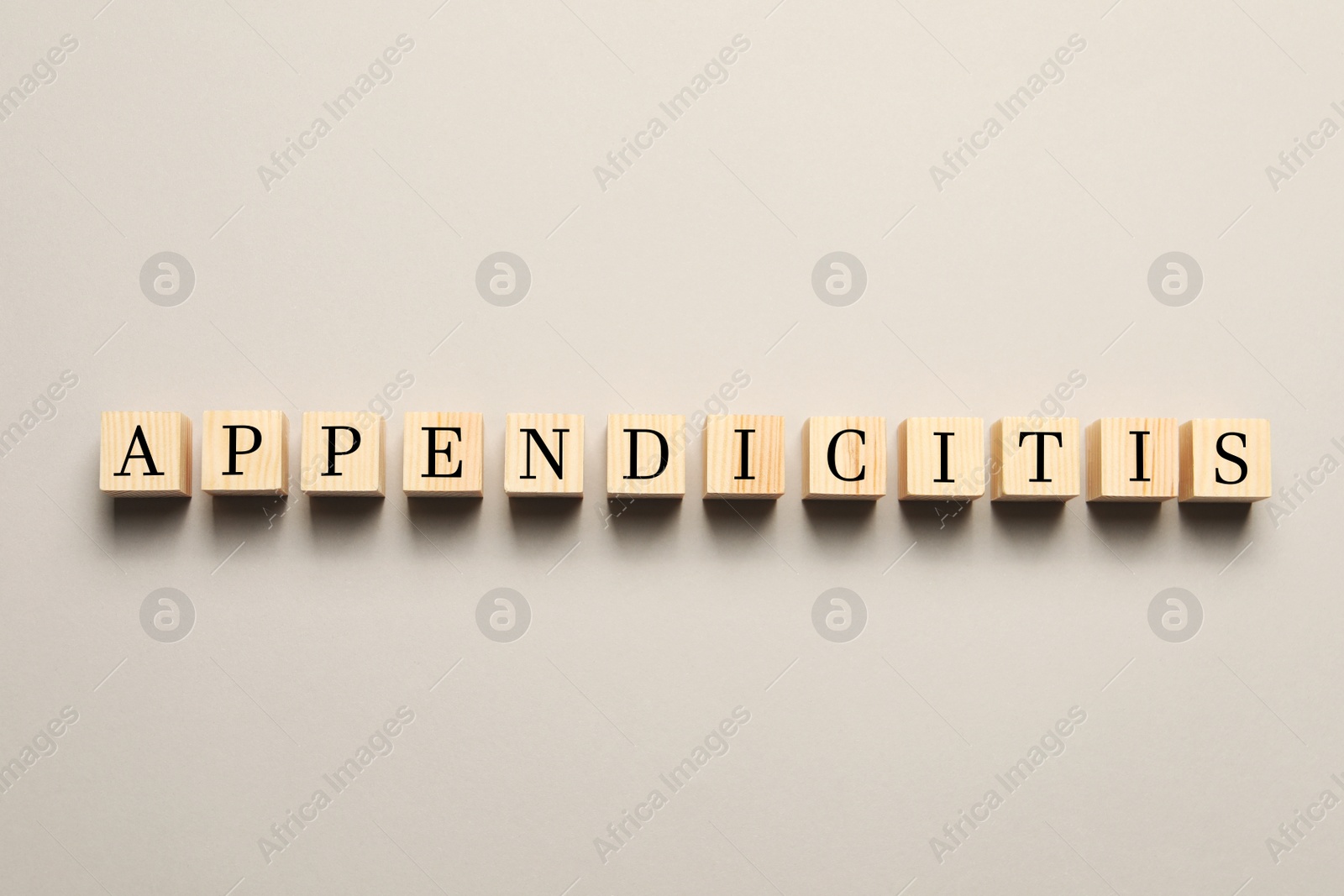Photo of Word Appendicitis made of wooden cubes with letters on light background, top view