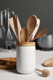 Photo of Set of different kitchen utensils on white wooden table against grey background