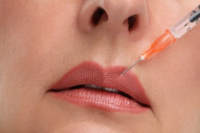Senior woman getting lips injection, closeup. Cosmetic surgery