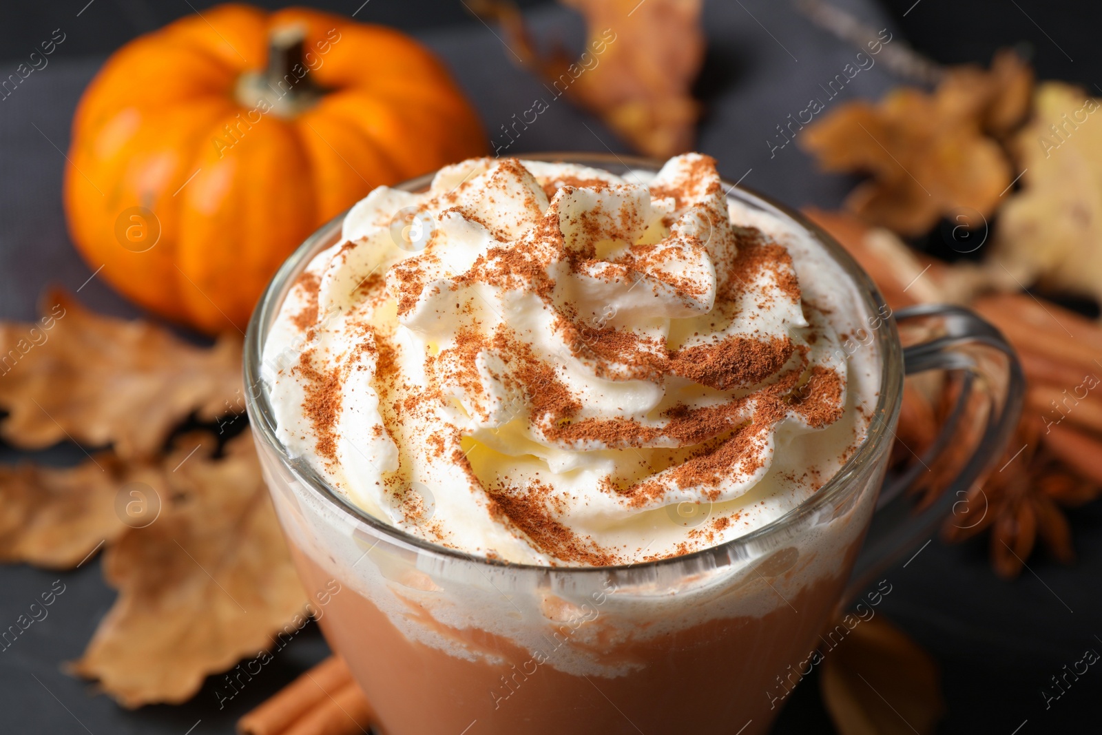 Photo of Delicious pumpkin latte with whipped cream on table, closeup