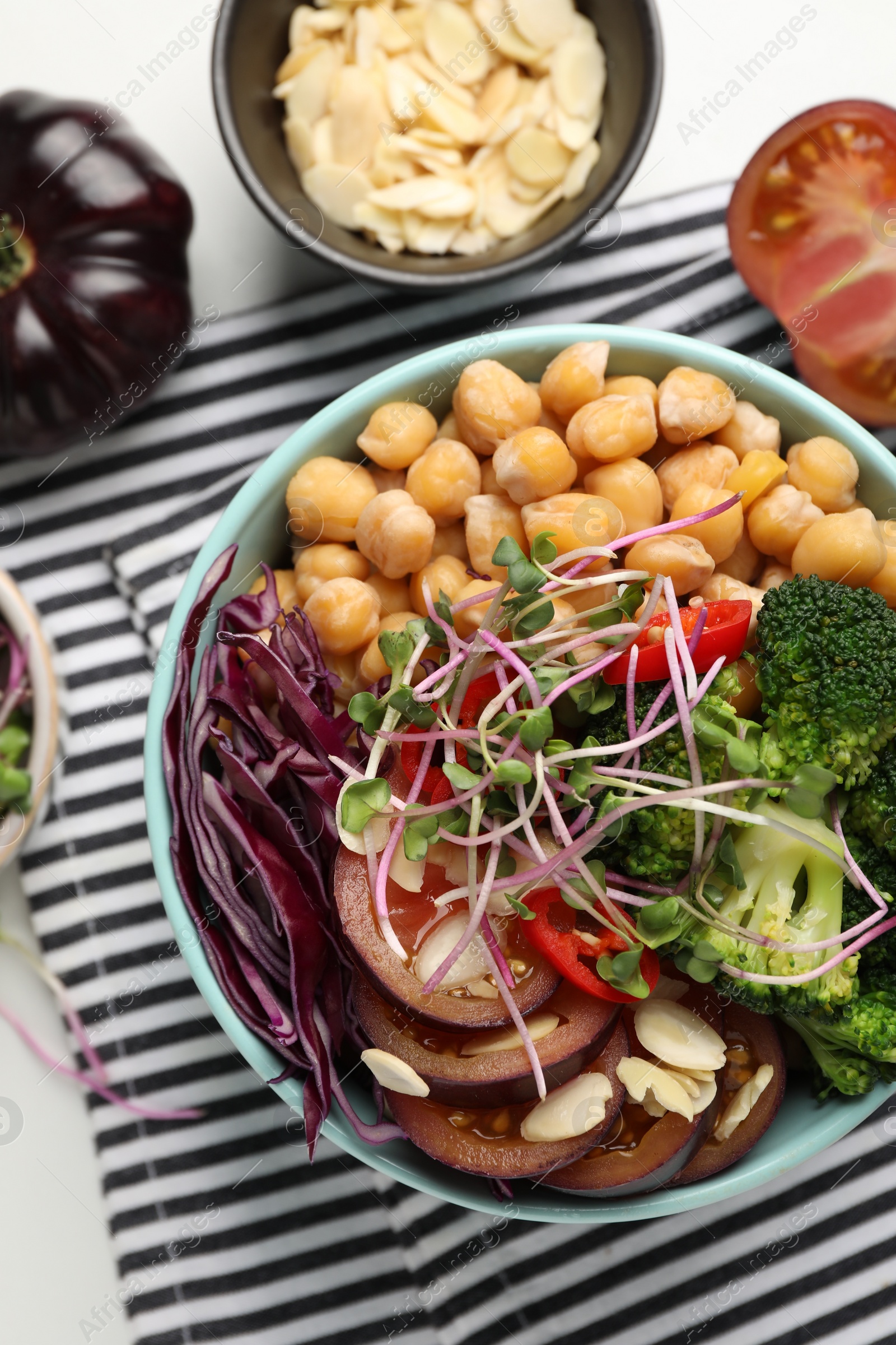 Photo of Delicious vegan bowl with broccoli, red cabbage and chickpeas on white table, flat lay