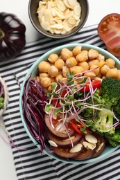 Delicious vegan bowl with broccoli, red cabbage and chickpeas on white table, flat lay