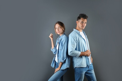 Photo of Young couple in stylish jeans on color background