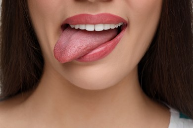 Photo of Woman with nude lipstick showing her tongue, closeup