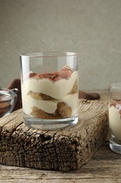 Delicious tiramisu in glass on wooden table