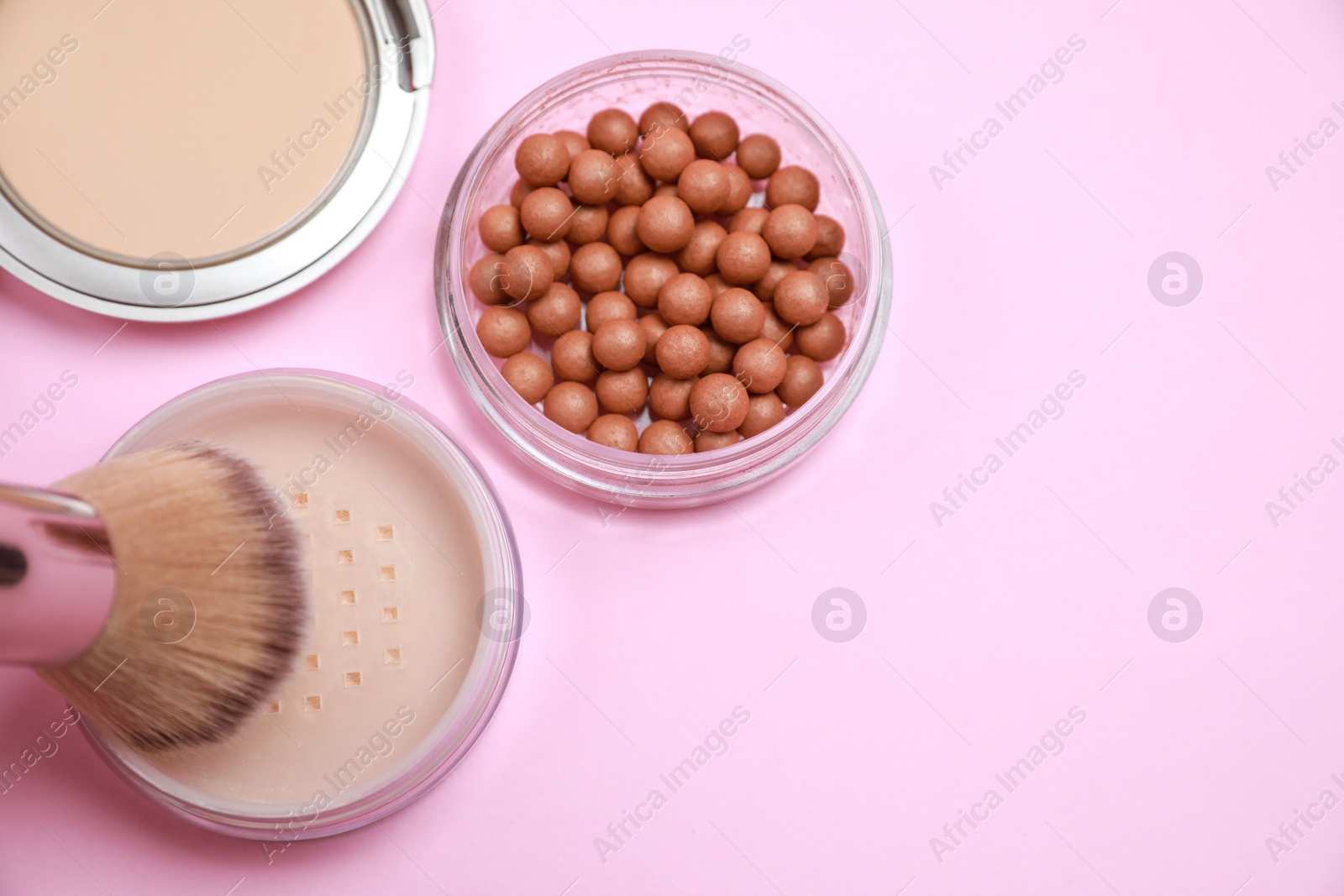 Photo of Applying face powder on brush on pink background, flat lay. Space for text