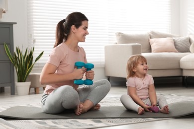Mother doing exercise with her daughter at home