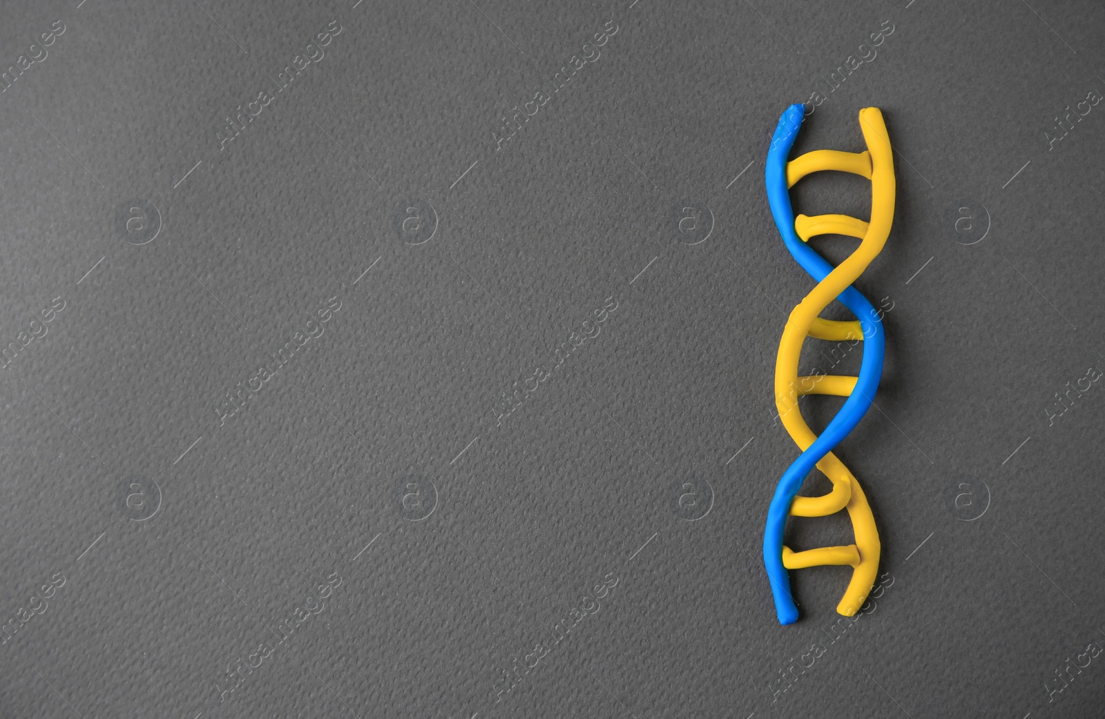 Photo of DNA molecule model made of colorful plasticine on black background, top view. Space for text