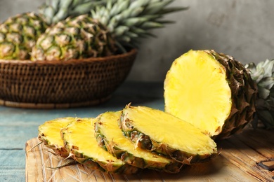 Photo of Board with cut fresh juicy pineapple on wooden table, closeup