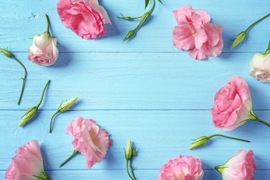 Photo of Flat lay composition with beautiful Eustoma flowers on wooden background